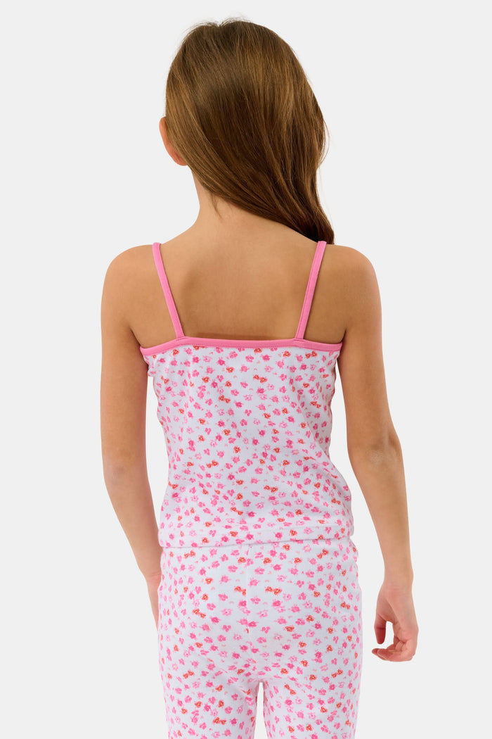 A young girl with long brown hair wears the Roller Rabbit Kids Bouquet Campbell Set, a pink and white pajama set with a floral print. She stands barefoot, smiling, against a plain light background with one foot slightly raised.