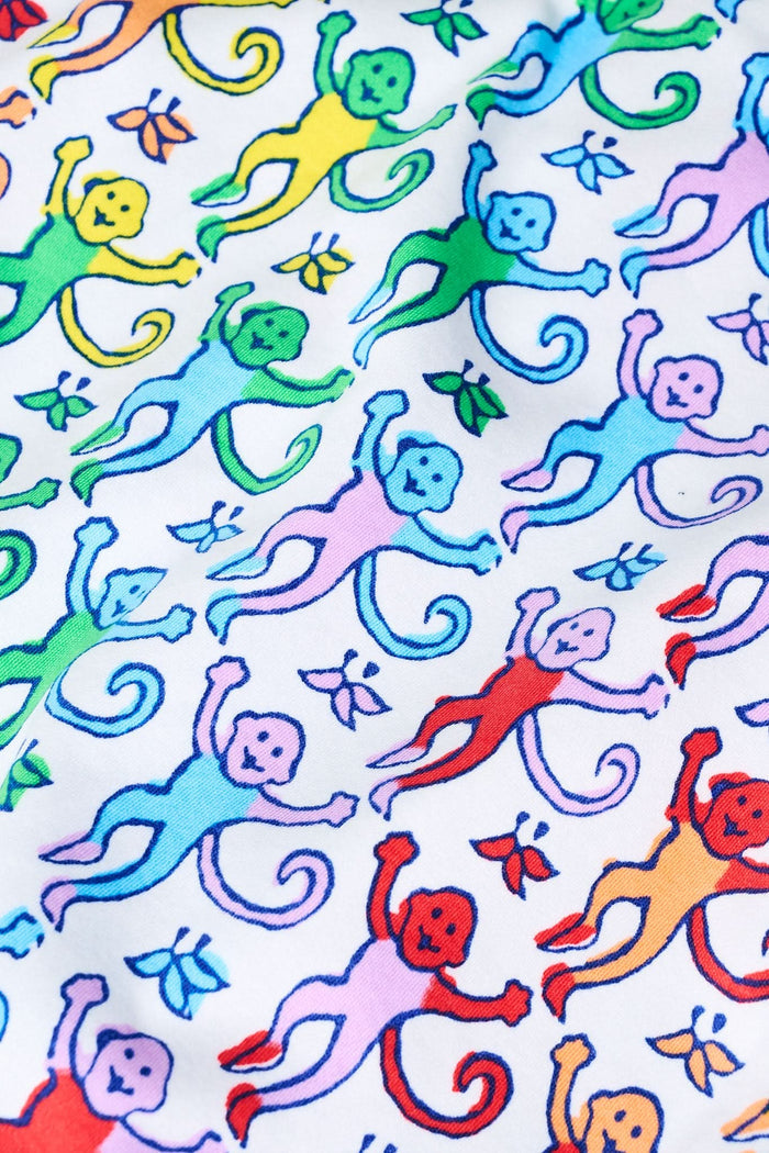 The Roller Rabbit Infant Disco Monkey Zipper Footie is a long-sleeved, footless romper made of 100 pima cotton with a white base and bright red, blue, green, and yellow monkey prints plus solid white cuffs and neckline.