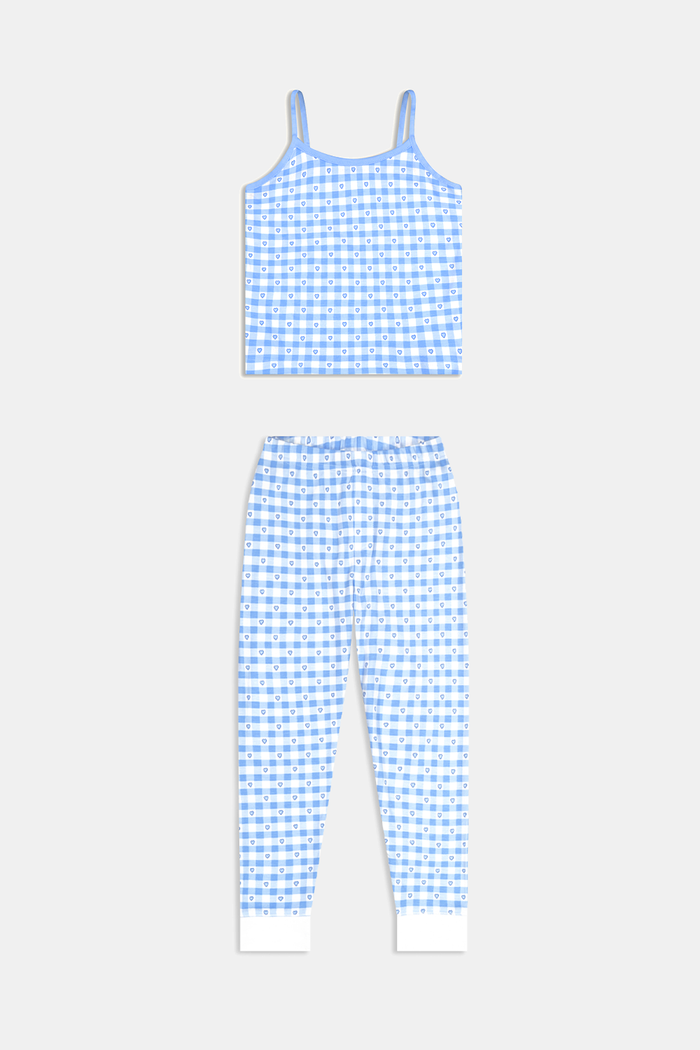 A young girl smiles barefoot in the Roller Rabbit Kids Gingham Hearts Campbell Set, featuring blue and white gingham loungewear with spaghetti straps and fitted pants, posed against a plain white background.