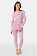 A girl stands barefoot wearing Roller Rabbit Kids Hathi Pajamas—a pink and white, long-sleeve, full-length set with white cuffs and a buttoned neckline—against a plain light background.
