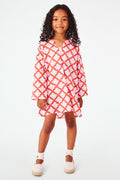 A young girl with curly hair smiles, wearing the Roller Rabbit Kids Jemina Kurta and beige espadrille sandals, standing against a plain white background.