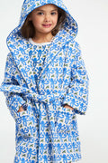 A young girl stands smiling in a Roller Rabbit Kids Monkey Cosmo Bathrobe over a matching shirt, against a plain white background.