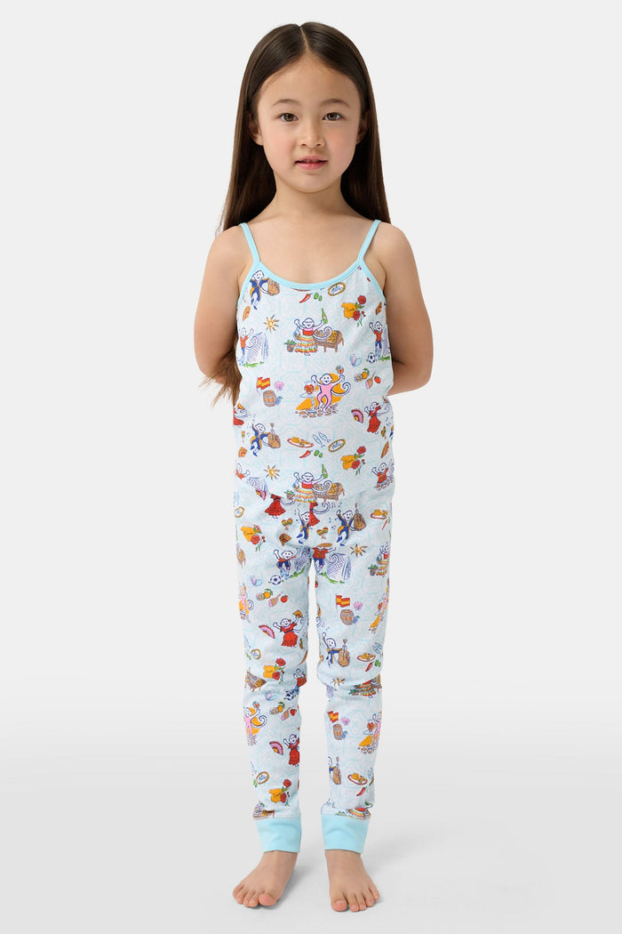 Young child with long brown hair stands barefoot, wearing the Roller Rabbit Kids Spain Monkey Noa Set—light blue Pima cotton loungewear with playful monkey prints and blue trim—against a plain white background.