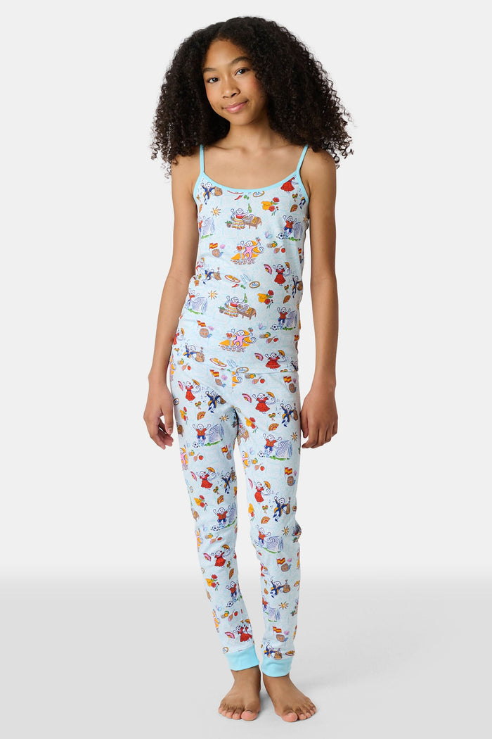 Young child with long brown hair stands barefoot, wearing the Roller Rabbit Kids Spain Monkey Noa Set—light blue Pima cotton loungewear with playful monkey prints and blue trim—against a plain white background.