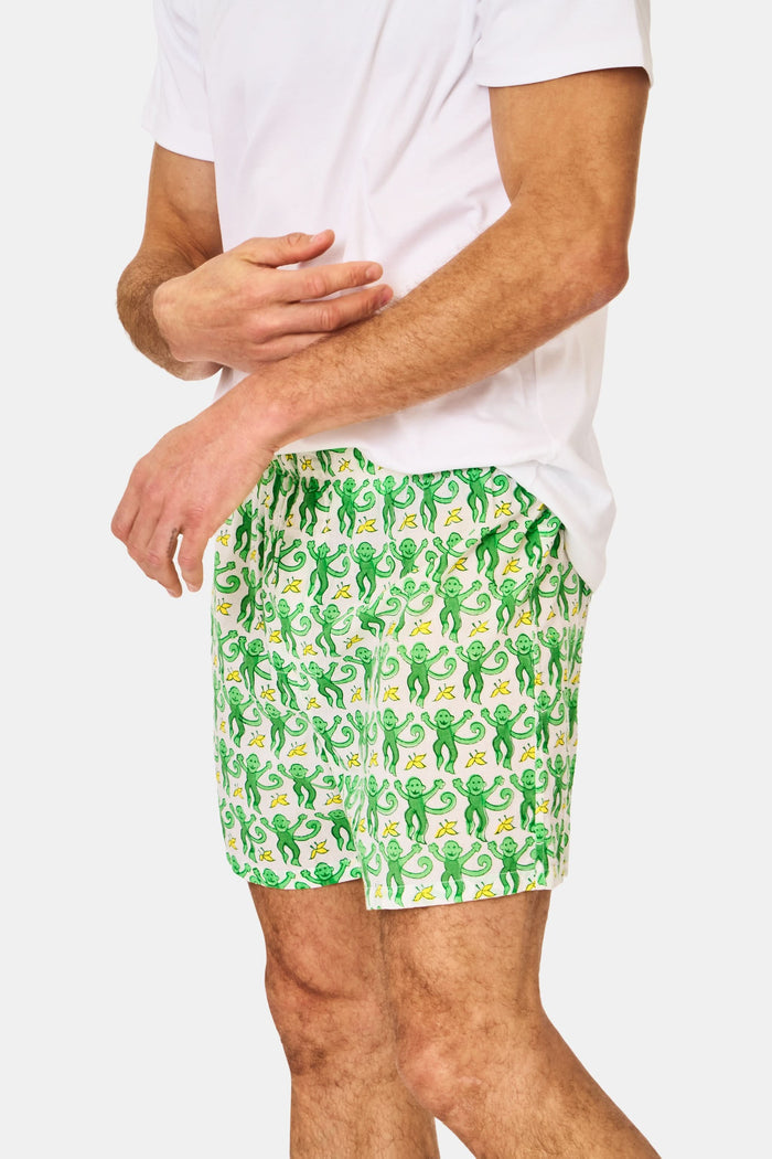 A man wearing Roller Rabbit’s Mens Monkey Boxer Set—a white T-shirt and cotton boxers—stands against a plain white background.