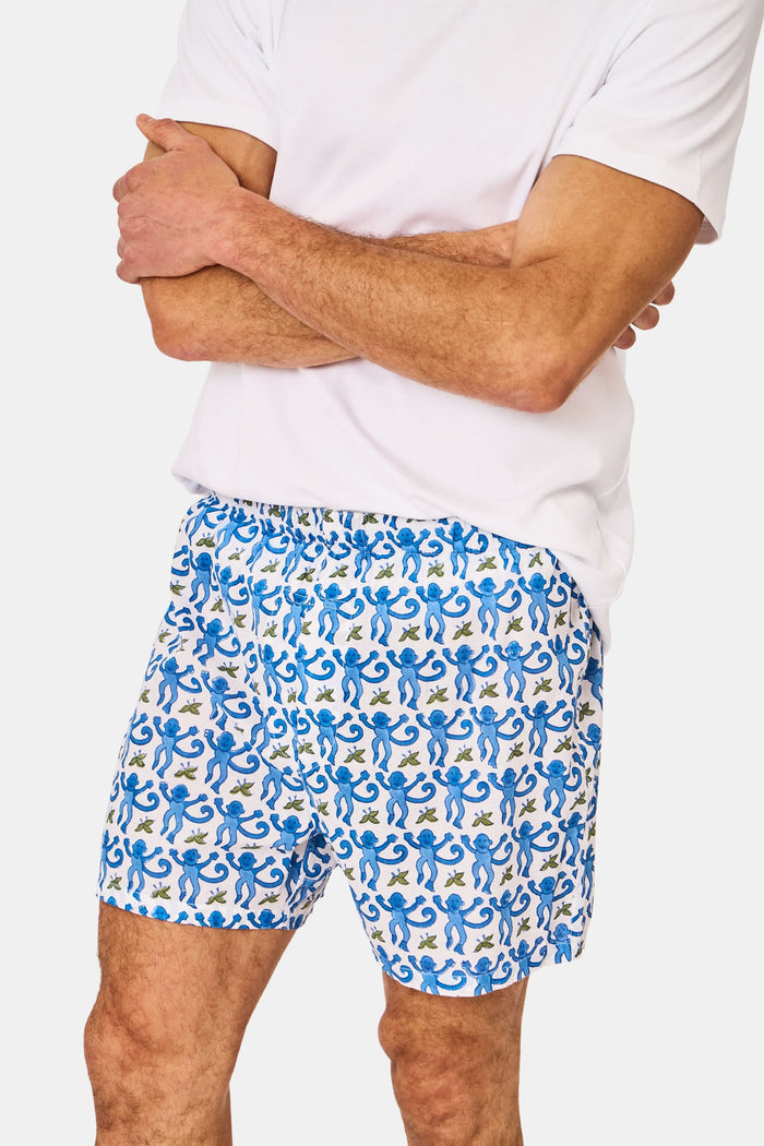 A man wearing Roller Rabbit’s Mens Monkey Boxer Set—a white T-shirt and cotton boxers—stands against a plain white background.
