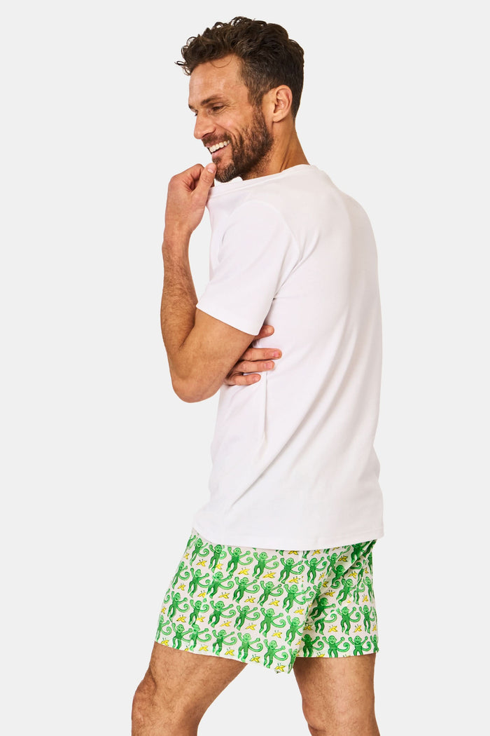 A man wearing Roller Rabbit’s Mens Monkey Boxer Set—a white T-shirt and cotton boxers—stands against a plain white background.