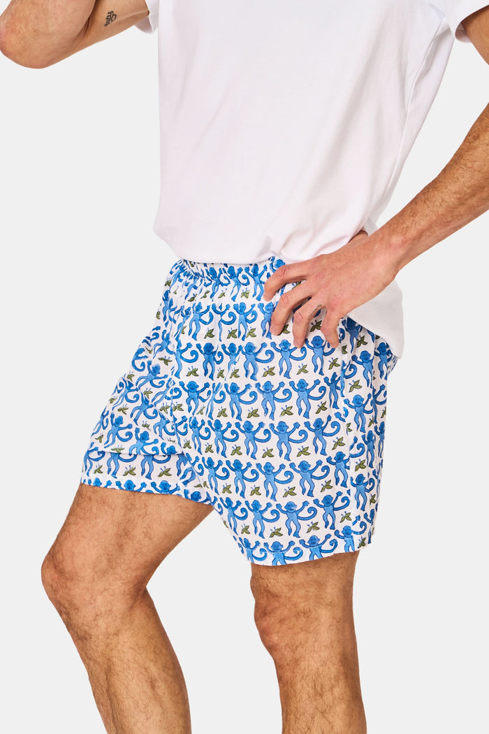 A man wearing Roller Rabbit’s Mens Monkey Boxer Set—a white T-shirt and cotton boxers—stands against a plain white background.