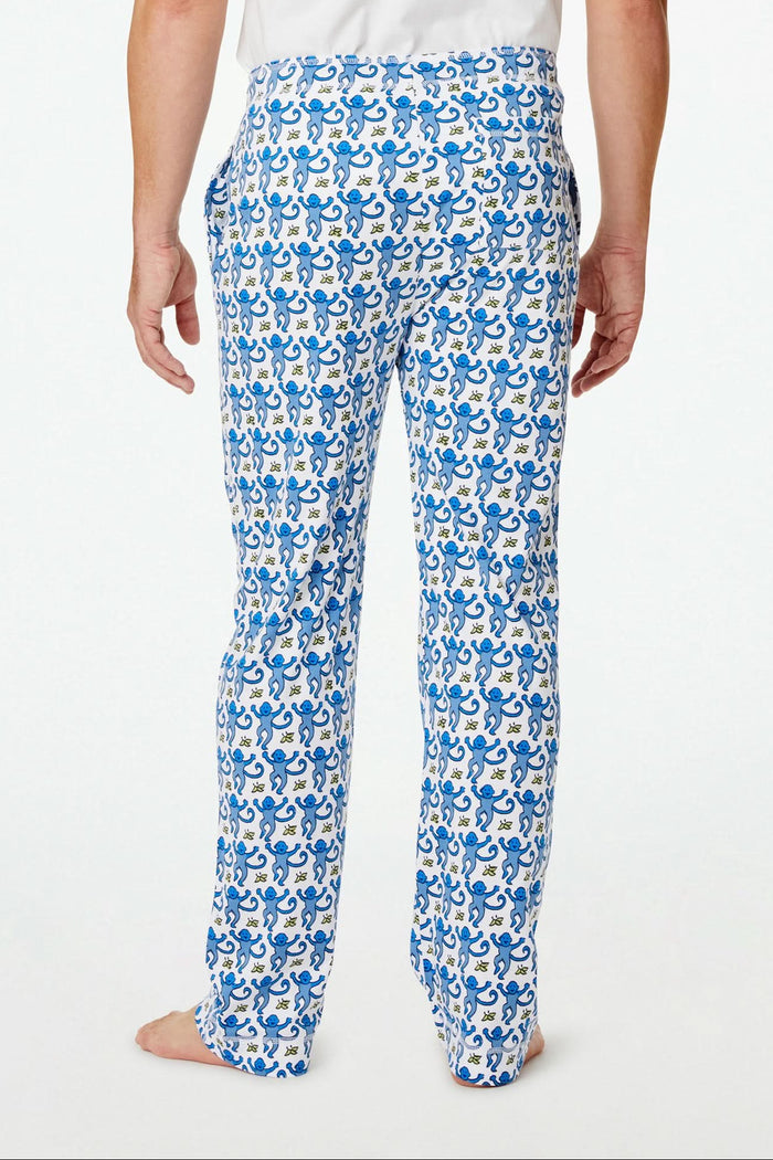 A person stands barefoot against a plain white background, showing only the lower half of their body while wearing Roller Rabbit Mens Monkey Simon Pant pajama pants.