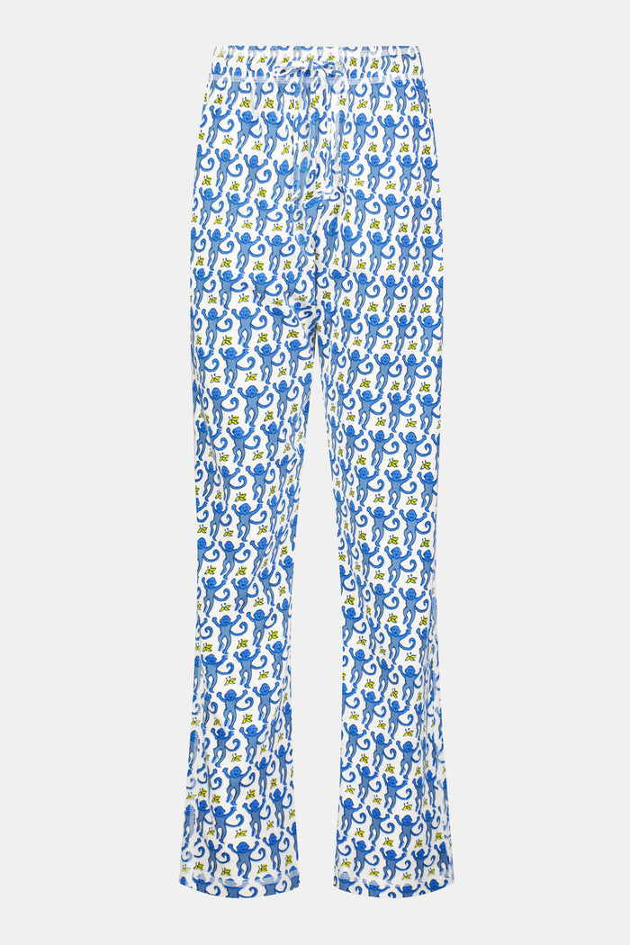 A person stands barefoot against a plain white background, showing only the lower half of their body while wearing Roller Rabbit Mens Monkey Simon Pant pajama pants.