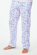 A person wears Roller Rabbit's Mens Nantucket Memories Simon Pant—white pajama pants with blue and red nautical prints like lighthouses, whales, and ship wheels. Only the lower half of the body is shown in the photo.