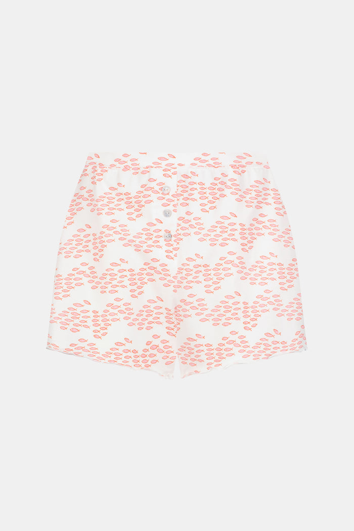 A person is wearing the Roller Rabbit Minnows Sullivan Shortie—a matching slumber party PJ set with a white base, pink zig-zag minnow print, sleeveless top, high-waisted shorts, wavy hem, and front buttons.
