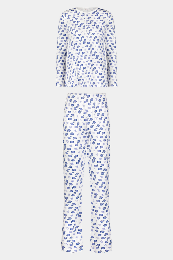 A woman with long blonde hair wears the Roller Rabbit Moby Pajamas, featuring a blue and white repeating print, as she stands barefoot against a plain white background.