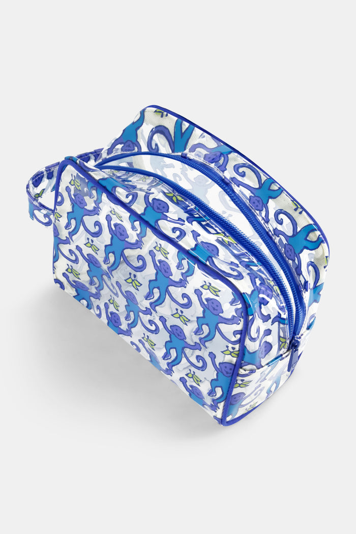 The Roller Rabbit Monkey Beach Pouch is a clear PVC bag with blue trim, decorated with cheerful blue cartoon monkeys—some holding bananas. Water-resistant and practical, it features a left-side handle for easy carrying.