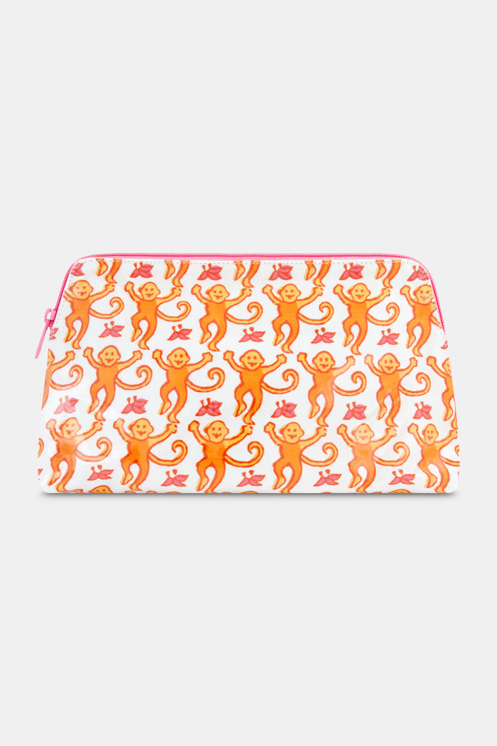 The Roller Rabbit Monkey Makeup Bag features a white cotton canvas with a pink zipper, adorned with orange monkeys and red leaves. Perfect for travel or daily makeup essentials.
