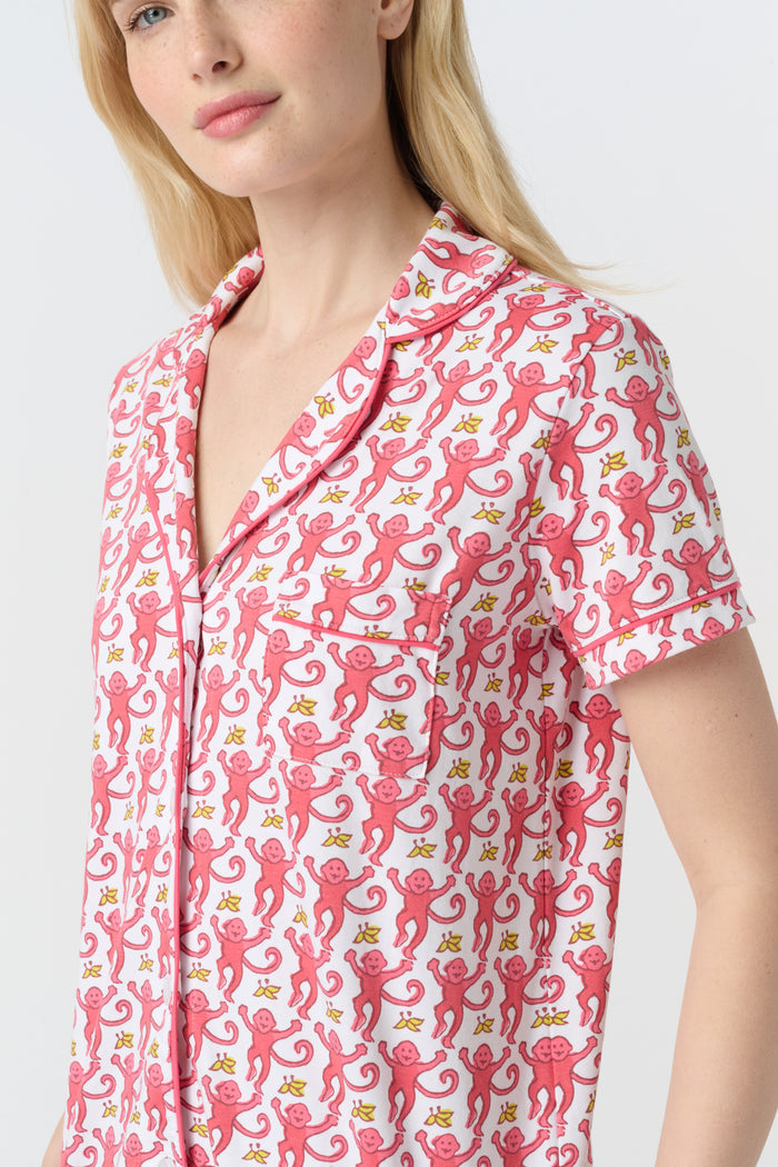 A woman with long blonde hair wears Roller Rabbit's Monkey Polo Pajamas—a matching polo-style top and bottom set—standing against a plain white background.
