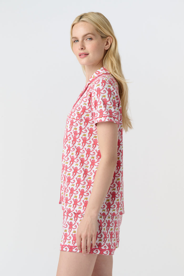 A woman with long blonde hair wears Roller Rabbit's Monkey Polo Pajamas—a matching polo-style top and bottom set—standing against a plain white background.