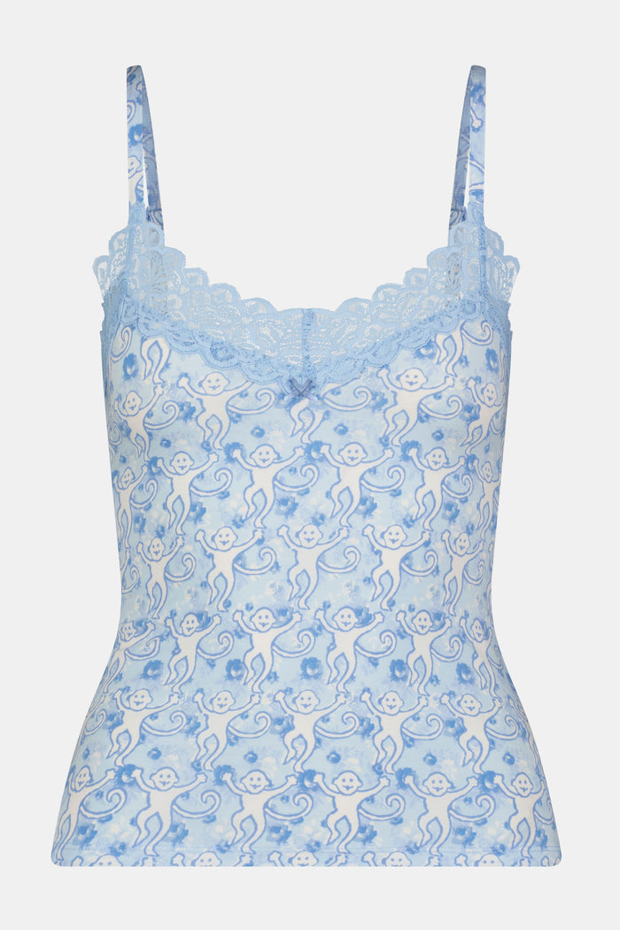 A woman poses against a plain background wearing the Roller Rabbit Monkey Rosette Perry Cami—a light blue, lace-trimmed camisole and matching underwear with a delicate floral pattern, perfect for flirty lingerie looks.
