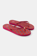 The Roller Rabbit Palm Fronds Flip Flops feature burgundy soles with orange and white geometric patterns, solid red straps with gold accents, and are perfect as swimwear matching sandals. Displayed on a white background.