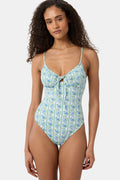 A woman models the Roller Rabbit Provencal Stripe Aurora One Piece, a blue and green vintage-inspired swimsuit with thin straps and a front keyhole, against a white background. This UPF 50+ swimwear combines style and sun protection.