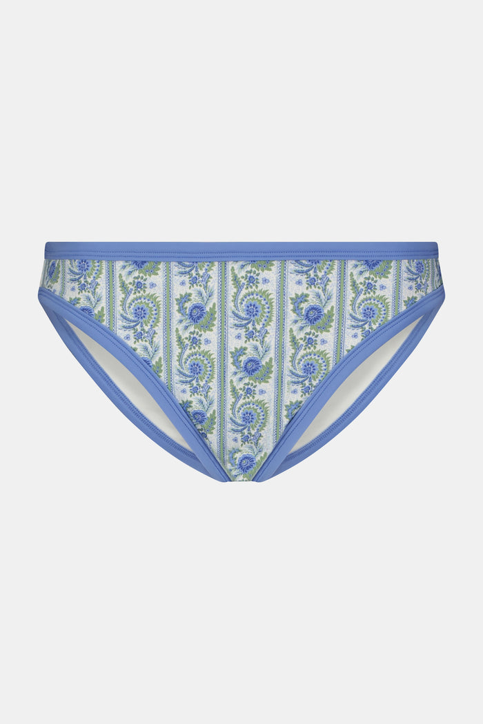 A person shown from the waist to upper thighs is wearing the Roller Rabbit Provencal Stripe Oceana Bikini Bottom featuring a blue and green floral design with light blue trim in a high-waisted bikini style.
