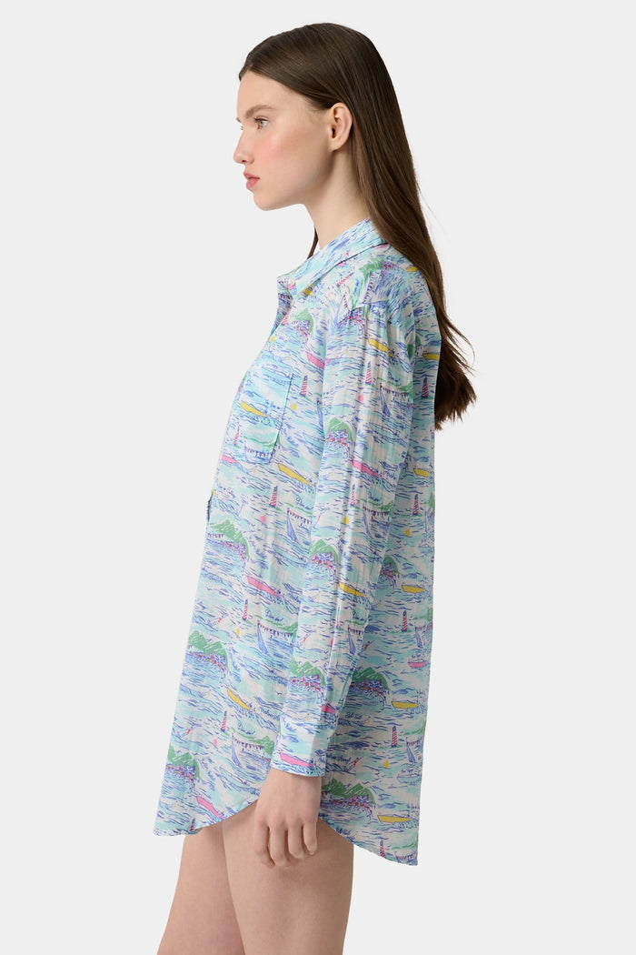 A woman wears the Roller Rabbit Regatta Boyfriend Dress, a loose-fitting cotton voile piece with long sleeves and colorful pastel abstract patterns. The thigh-length dress features a relaxed fit as she stands against a plain, light background.