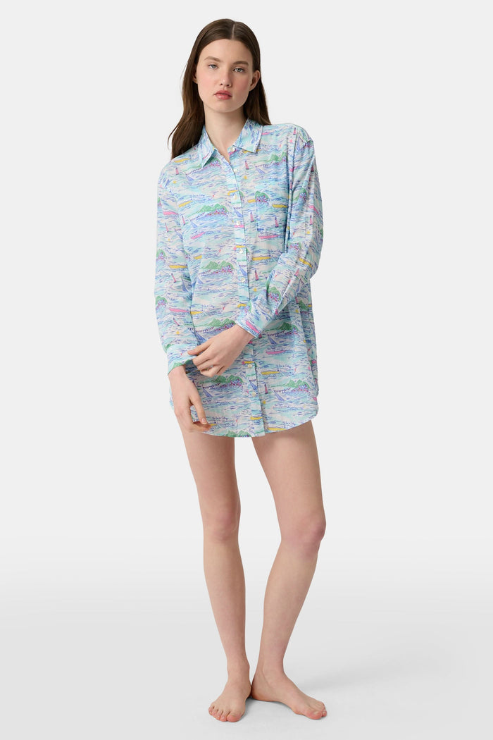 A woman wears the Roller Rabbit Regatta Boyfriend Dress, a loose-fitting cotton voile piece with long sleeves and colorful pastel abstract patterns. The thigh-length dress features a relaxed fit as she stands against a plain, light background.