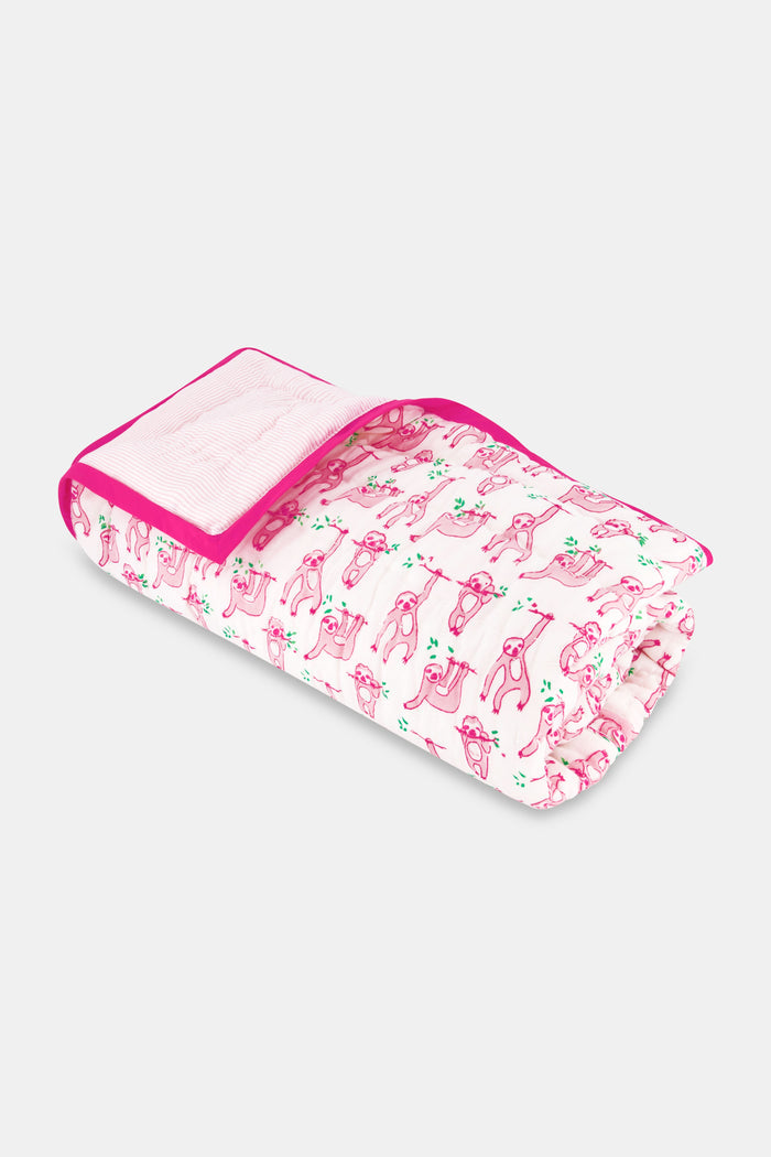 The Roller Rabbit Sleepy Sloth Baby Quilt is a folded white cotton quilt with pink trim, decorated with playful pink sloths and green cacti, neatly displayed on a plain white background.