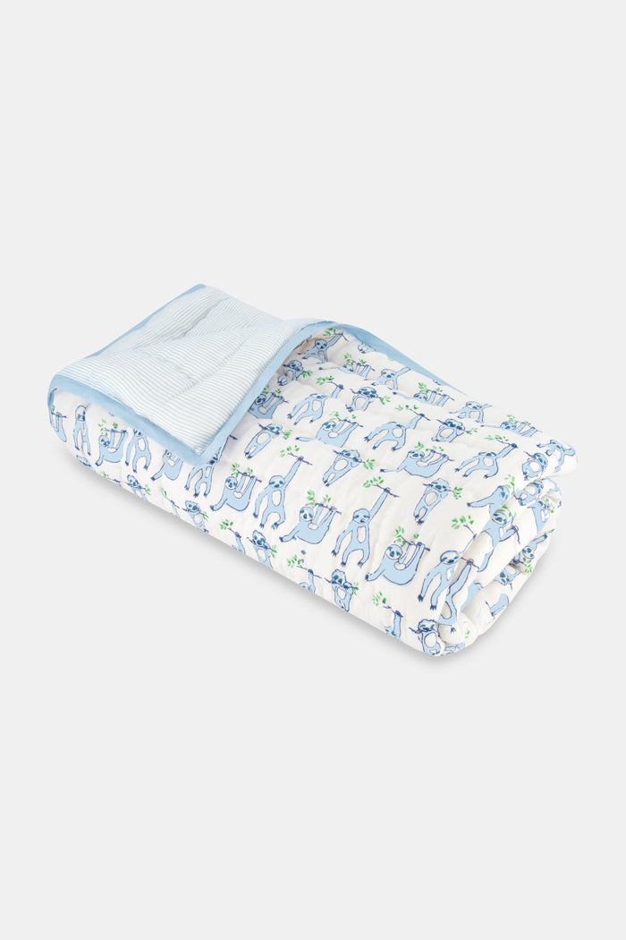 The Roller Rabbit Sleepy Sloth Baby Quilt is a soft cotton, white quilt with a blue border and playful sloth illustrations. Blue and gray sloths hold green leaves, while the inner lining features a light blue striped pattern.