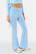 A person wearing Roller Rabbit's Stars Ally Flared Leggings in sky blue with a star print waistband, paired with a matching tied long-sleeve top and white sneakers. Only the lower body is visible.