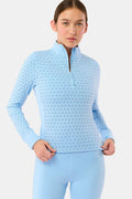 A woman wears the Roller Rabbit Stars Celia Quarter Zip in sky blue with a subtle star pattern and matching blue leggings, standing against a plain white background.