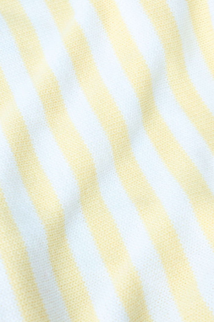A young woman with light skin and long brown hair wears the Roller Rabbit Striped Rocio Sweater, a pastel yellow, lightweight cotton knit with a wide V-neck and collar. She pairs it with matching drawstring pants and gazes slightly to the side.
