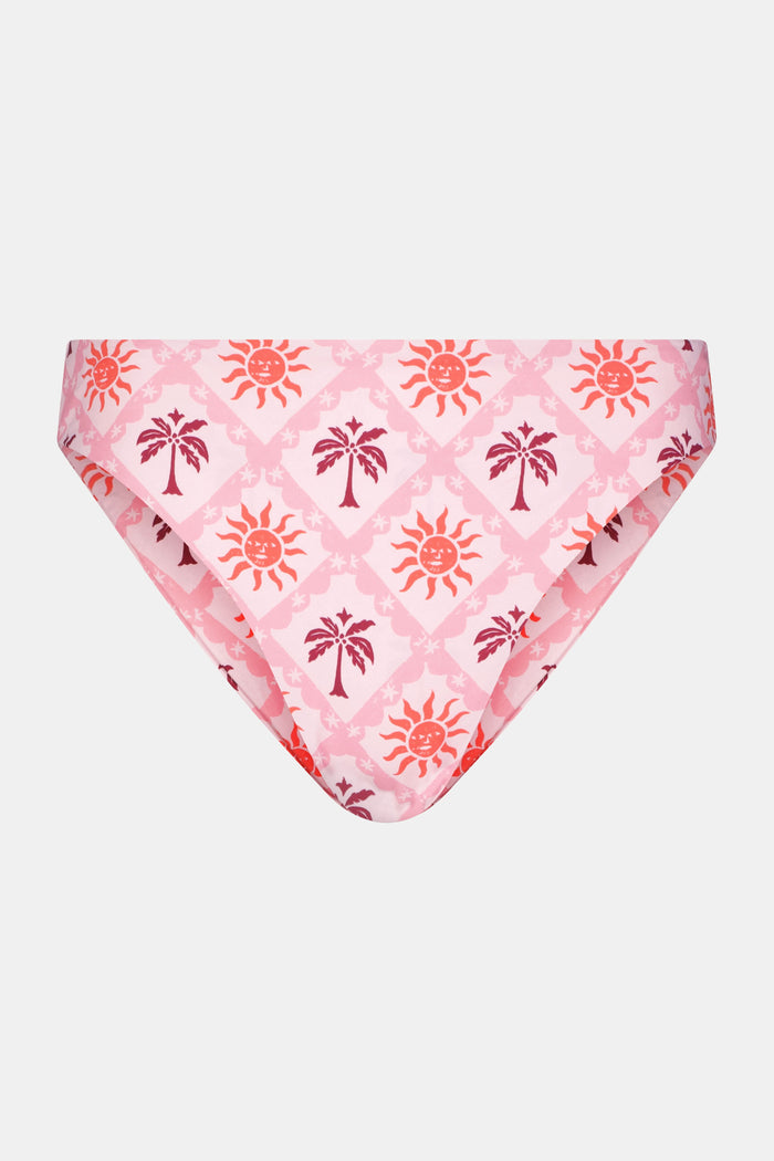 A model wears the Roller Rabbit Sunny Days Shelly Bikini Bottom, featuring orange and purple sun and palm tree patterns, shown from mid-torso to upper thigh against a plain background.
