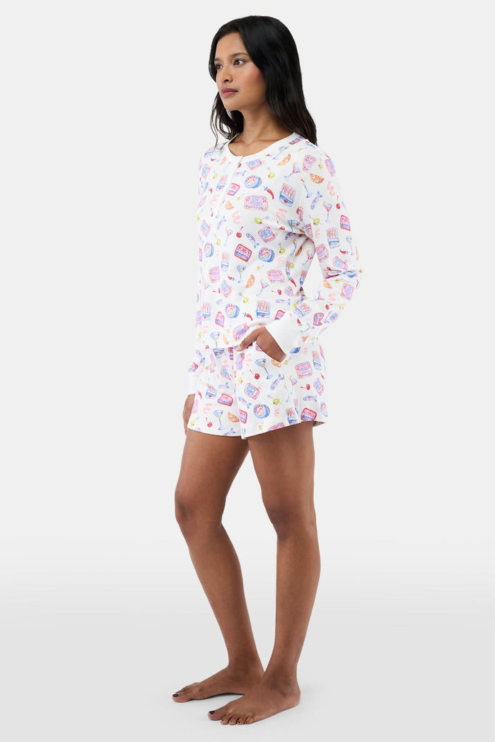 A person stands barefoot in the Roller Rabbit Tinned or Twist Brooklyn Boxer, a white pajama bottom with playful food and drink prints and a comfy elastic waistband. Only the lower half of the body is shown against a plain background.