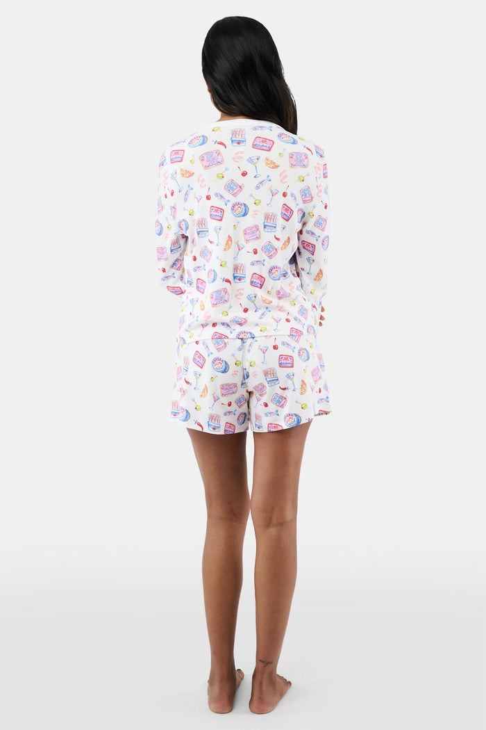 A person stands barefoot in the Roller Rabbit Tinned or Twist Brooklyn Boxer, a white pajama bottom with playful food and drink prints and a comfy elastic waistband. Only the lower half of the body is shown against a plain background.