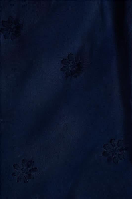 A woman models the Roller Rabbit Vanna Embroidery Margaret Dress—a short-sleeve navy linen shirtdress with a belted waist—standing against a plain light background.